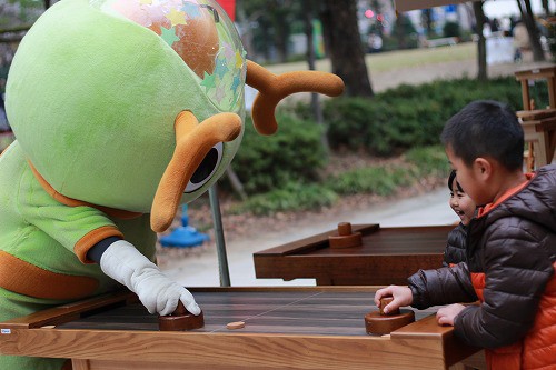木のホッケーで遊ぶナシローと子ども達